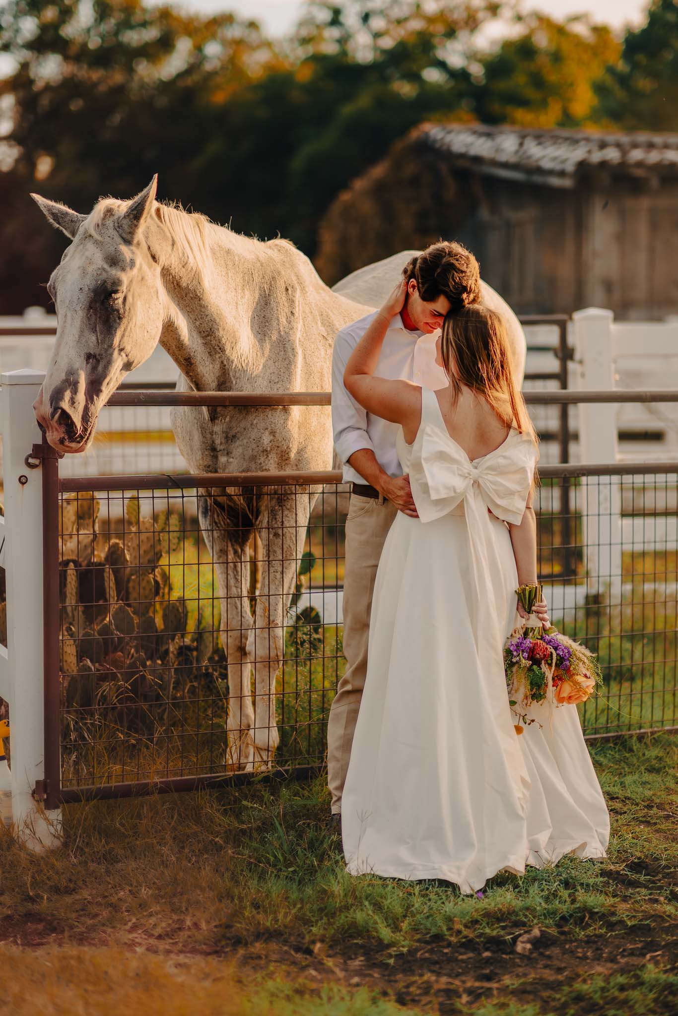 Bride and groom embracing by a horse on a Texas farm during a styled after-wedding shoot.